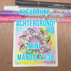 Mini-mandala getekend met zwarte en neonroze gelpen op kleurrijk papier.