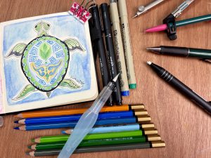 Inktober Mini-Mandala #40: schildpad met een mandalapatroon op het schild in groen en blauw, omringd door water.